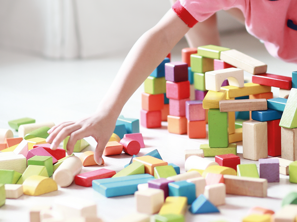 Bildausschnitt, Kinderhand greift zu Bauklötzen, Adoptionsdienst Berlin Bildausschnitt, Kinderhand greift zu Bauklötzen, Adoptionsdienst Berlin