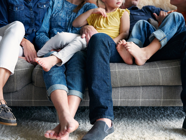 Familie sitzt vertraut auf Sofa zusammen Familie sitzt vertraut auf Sofa zusammen
